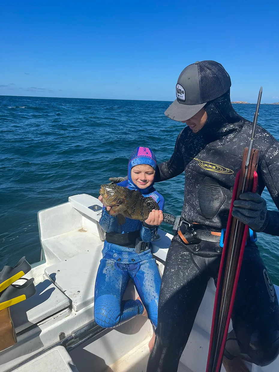 Beginner spearfisher swimming over shallow Pacific reef